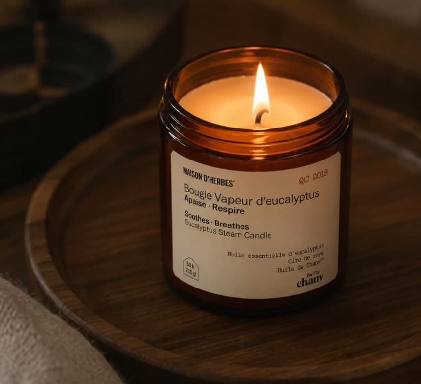 Bougie Vapeur d’eucalyptus allumée dans son pot ambré, sur un plateau de bois