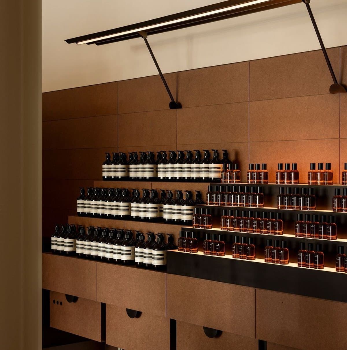 Rayonnages de bois éclairés garnis de flacons ambrés dans la boutique